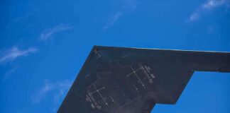 Stealth bomber flying in a clear blue sky.