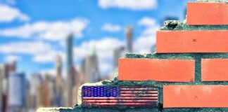 bricks with text written in paint before the skyline of New York City