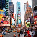 Times Square crowded with people and bright electronic advertisements.