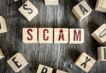 Wooden blocks spell "SCAM" on a rustic surface.
