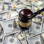$80 Million Verdict in Chicago: What It Means for Police Policies? Gavel on pile of hundred dollar bills