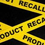 Packaging Mistake Triggers Urgent Recall Yellow product recall tape on black background.