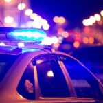 CEO Shot Dead in Shocking Assassination Police car with blue lights at night.