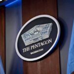 Pentagon Settles Court Case Opening Benefits to Thousands of LGBTQ+ Veterans Pentagon sign flanked by flags, Washington, D.C.
