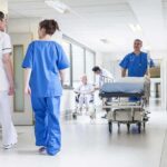 Exploring Strategies to Tackle the US Nurse Shortage Crisis Doctors and nurses in hospital corridor with stretcher