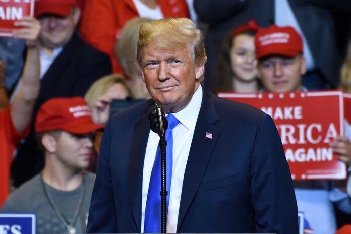 1149680009 featured image Person at a rally with Make America Great Again signs.