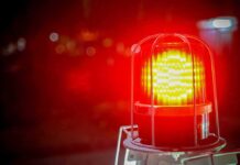 Flashing red warning light with blurred background.