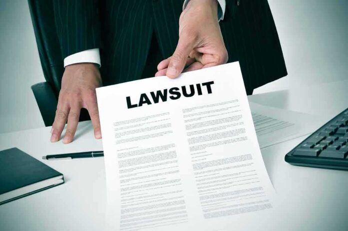 189871757 featured image Person holding a document labeled "Lawsuit."