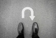 Feet in black shoes facing U-turn road marking