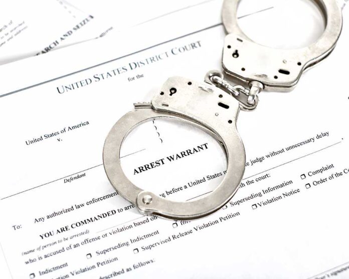1316784506 featured image Handcuffs on an arrest warrant document