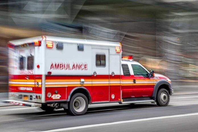 1495131698 featured image Red and white ambulance driving on street.