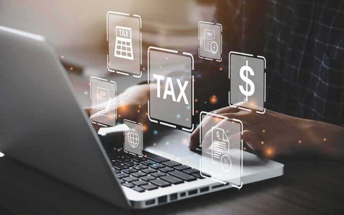 2018230646 featured image Person typing on laptop with tax-related icons displayed.