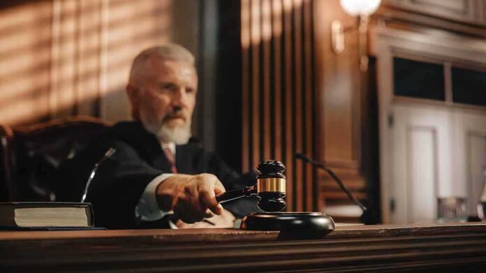 2056414451 featured image Judge holding gavel in a courtroom setting.