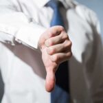 Person giving a thumbs down gesture.