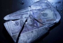 Hundred dollar bills frozen in cracked ice block