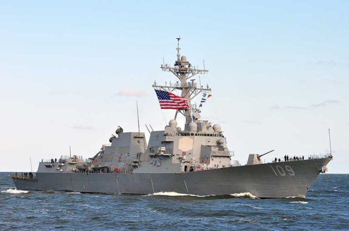 581405539 featured image Military ship sails with American flag.