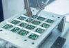 Robotic arm assembling electronic circuit boards in production