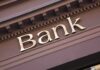 Gold bank sign on building facade
