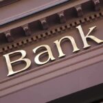 Gold bank sign on building facade