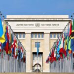 United Nations building with numerous national flags outside.