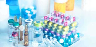 Vials and blister packs of pills on table