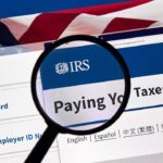 Magnifying glass over IRS website for paying taxes