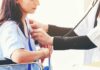 Doctor examining patient with stethoscope in hospital