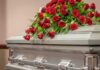 Silver casket with red rose arrangement on top