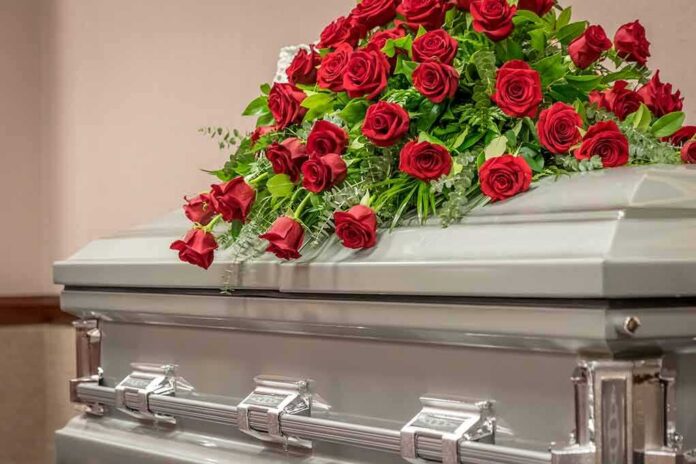 Silver casket with red rose arrangement on top