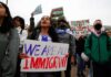 People at protest holding signs about immigration rights