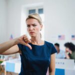Woman with thumbs down in voting location