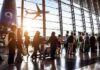 Passengers waiting at airport gate with airplane outside window