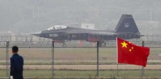 Jet with 31001 marking behind barbed wire fence