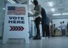 Sign reading Vote Here in a polling station