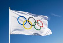 Olympic flag waving against clear blue sky