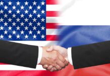Hands shaking in front of USA and Russia flags