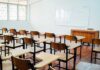 Empty classroom with desks chairs and whiteboard