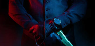 Man holding gun and rosary with cross.