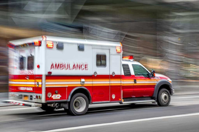 Red and white ambulance driving on street