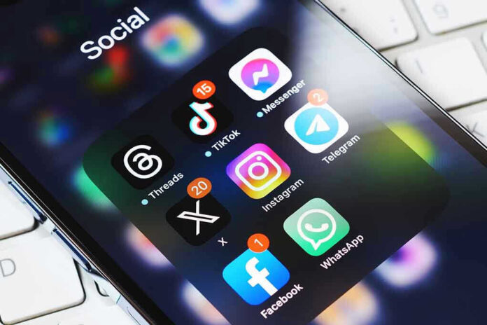 2339442245 Smartphone showing social media app icons in a folder