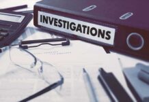 Documents and binder labeled investigation on desk.
