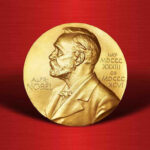 Gold Nobel Prize medal on red background