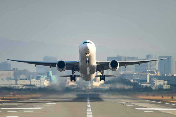 559714906 Airplane taking off from runway in urban area