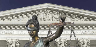 Lady Justice statue in front of courthouse.