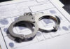 Handcuffs on fingerprint form with fingerprints visible