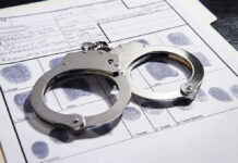 Handcuffs on fingerprint form with fingerprints visible