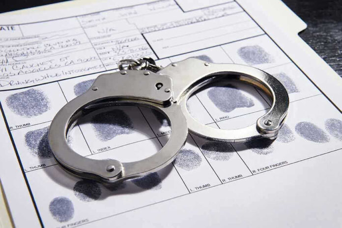 Handcuffs on fingerprint form with fingerprints visible