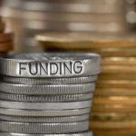 Stack of coins labeled funding with other coins stacks