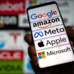 Hand holding phone displaying tech company logos