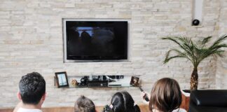 A family of four watching television together in a cozy living room